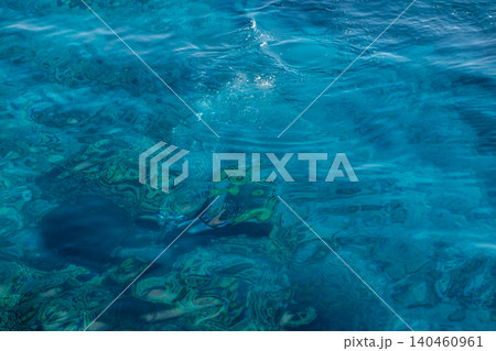 Turquoise water reveals vibrant coral reefs and fish swimming below, ideal for snorkelers exploring the underwater ecosystem on a bright day. 140460961