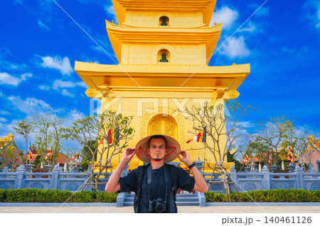 tourist man at golden tower on Vietnamese Buddhist pagoda Truc Lam Phung Thuy Son in Nha Trang in Vietnam. Travel, tourism and sightseeing in Asia 140461126