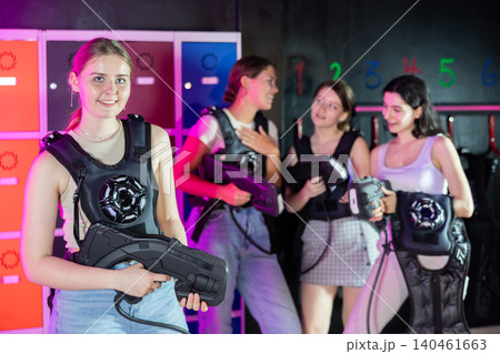 Cheerful and happy girl pose in locker room before laser tag match. Cheerful and happy girl pose in locker room before laser tag match. 140461663