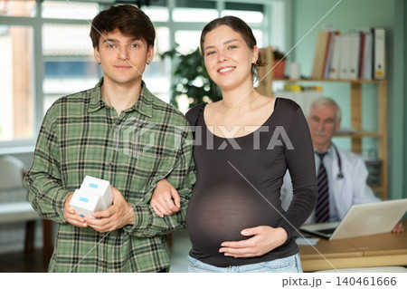 Pregnant woman and her husband came to a consultation with a doctor to get recommendations Pregnant woman and her husband came to a consultation with a doctor to get recommendations 140461666