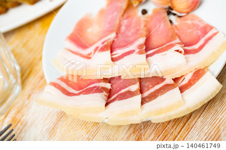 Sliced salted streaky pork bacon with garlic cloves Sliced salted streaky pork bacon with garlic cloves 140461749