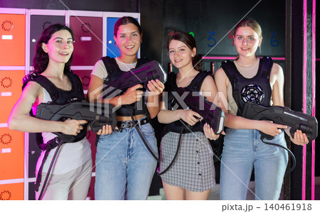 Four cheerful and happy girls pose in locker room before laser tag match. 140461918