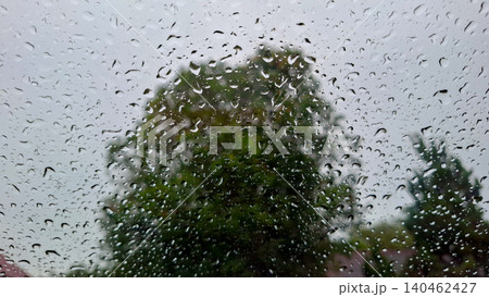 Clear Raindrops on Glass Window with Green Foliage Bokeh Clear Raindrops on Glass Window with Green Foliage Bokeh 140462427