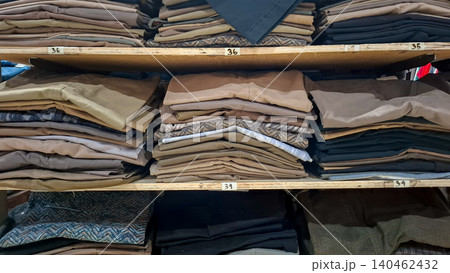 Organized Trousers Stacked on Wooden Shelves by Size Organized Trousers Stacked on Wooden Shelves by Size 140462432