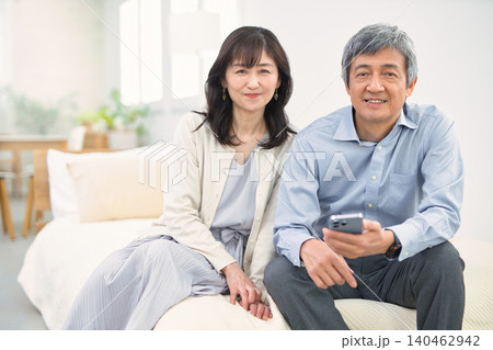 リビングで楽しく会話する60代の夫婦 リビングで楽しく会話する60代の夫婦 140462942