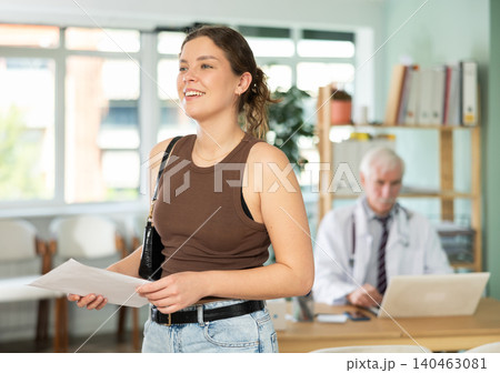 Happy young girl patient leaving medical office after doctor appointment holding prescription in hands in medical center Happy young girl patient leaving medical office after doctor appointment holding prescription in hands in medical center 140463081