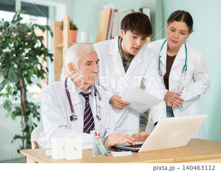 Three doctors work with laptop in clinic Three doctors work with laptop in clinic 140463112