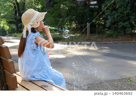 公園のベンチでシャボン玉遊びを楽しむ女の子 公園のベンチでシャボン玉遊びを楽しむ女の子 140463692