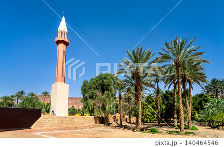 Beautiful red and white Bilal ibn Rabah Mosque minaret stands amidst lush palm trees in the historic AlUla Oasis of Saudi Arabia, under a bright blue sky. Beautiful red and white Bilal ibn Rabah Mosque minaret stands amidst lush palm trees in the historic AlUla Oasis of Saudi Arabia, under a bright blue sky. 140464546