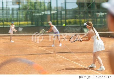 Concentrated sporty girl with tennis racquet and ball in her hands standing and ready to play match standing Concentrated sporty girl with tennis racquet and ball in her hands standing and ready to play match standing 140465047