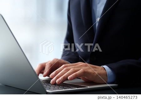 オフィスのデスクでノートパソコンを使うビジネスパーソン。手とキーボードのクローズアップ。ビジネスでの 140465273