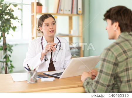 Female doctor discussing diagnostic results with young guy 140465550