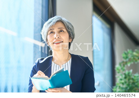 手帳を開いて考える女性 手帳を開いて考える女性 140465574