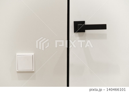 A home renovation project shows new doors with sleek handles and light switches in a contemporary style within a residential area. A home renovation project shows new doors with sleek handles and light switches in a contemporary style within a residential area. 140466101