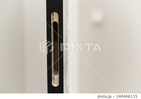 Workers are installing new doors as part of a home renovation project in a residential area during the afternoon. 140466135