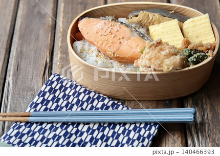 曲げわっぱに入れた焼き鮭の和食弁当と矢絣柄の包み布 140466393