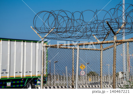 Sharp barbed wire border fence blocking access. Surveillance, conflict, and restricted freedoms, reflecting geopolitical divisions and the impact of immigration policies on displaced people. Sharp barbed wire border fence blocking access. Surveillance, conflict, and restricted freedoms, reflecting geopolitical divisions and the impact of immigration policies on displaced people. 140467221