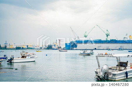 Large ship docked peacefully at busy port. Vital role of maritime logistics and transport. Commercial ships at harbor, showcasing global shipping and logistics. Transportation and maritime industry. Large ship docked peacefully at busy port. Vital role of maritime logistics and transport. Commercial ships at harbor, showcasing global shipping and logistics. Transportation and maritime industry. 140467280