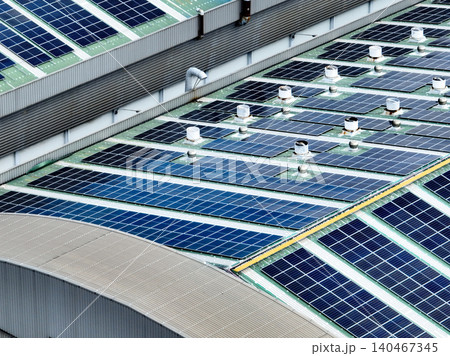 Rooftop solar panels on an industrial plant building. Clean and renewable power solutions, green energy innovation, and sustainable commercial electricity generation. Sustainable manufacturing. 140467345