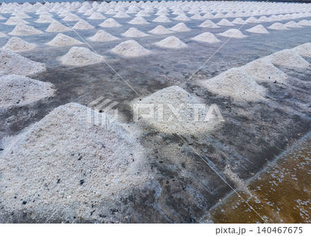 Sea salt farm. Pile of brine salt. Raw material of salt industrial. Sodium Chloride mineral. Evaporation and crystallization of sea water. White salt harvesting. Agriculture industry. Traditional farm Sea salt farm. Pile of brine salt. Raw material of salt industrial. Sodium Chloride mineral. Evaporation and crystallization of sea water. White salt harvesting. Agriculture industry. Traditional farm 140467675