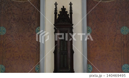 Antique Cabinet against Ornate Wall Design Antique Cabinet against Ornate Wall Design 140469495