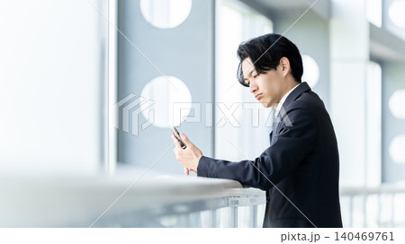 スマートフォンを見て悩む男性ビジネスマン スマートフォンを見て悩む男性ビジネスマン 140469761