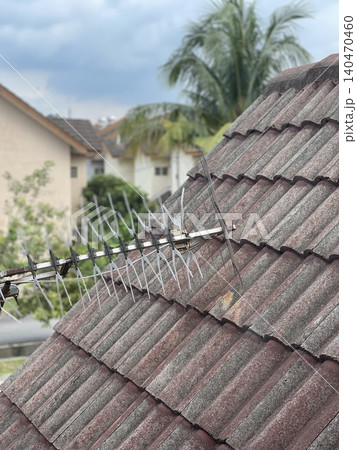 TV antenna on old tiled roof with moss in tropical residential area TV antenna on old tiled roof with moss in tropical residential area 140470460