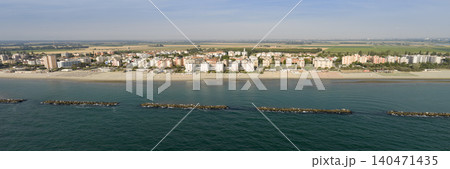 Panorama shot of sandy beach with umbrellas and gazebos.Summer vacation concept.Lido Adriano town,Adriatic coast, Emilia Romagna,Italy. Panorama shot of sandy beach with umbrellas and gazebos.Summer vacation concept.Lido Adriano town,Adriatic coast, Emilia Romagna,Italy. 140471435