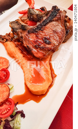 Grilled pork chops with sweet potato puree and fresh salad enjoyed during summer vacation in croatia 140471804