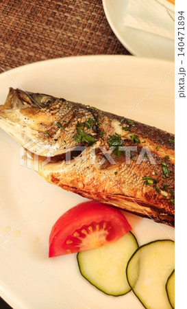 Grilled sea bass with vegetables enjoyed during summer vacation in croatia Grilled sea bass with vegetables enjoyed during summer vacation in croatia 140471894