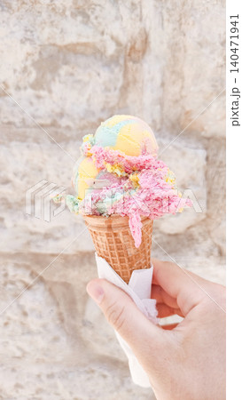 Tourist hand holding melting ice cream cone in croatia during summer vacation Tourist hand holding melting ice cream cone in croatia during summer vacation 140471941