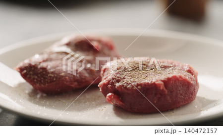 Two raw steak fillets on white plate in close-up kitchen scene 140472157