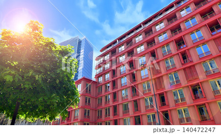 View of an modern apartment building standing next to a new modern office building with a glass facade. 140472247