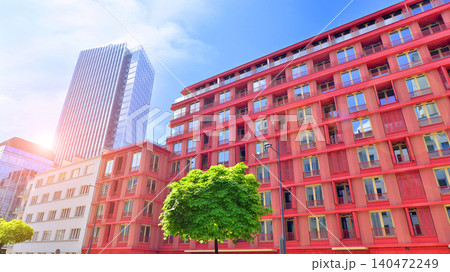 View of an modern apartment building standing next to a new modern office building with a glass facade. 140472249