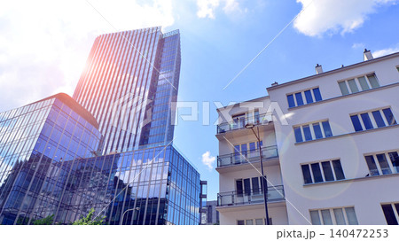 View of an modern apartment building standing next to a new modern office building with a glass facade. 140472253