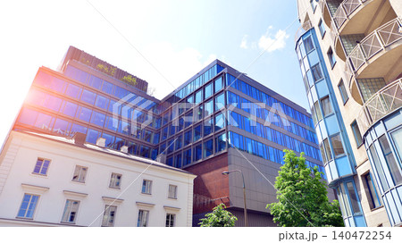 View of an modern apartment building standing next to a new modern office building with a glass facade. View of an modern apartment building standing next to a new modern office building with a glass facade. 140472254