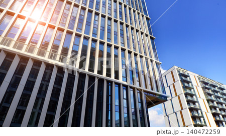 View of an modern apartment building standing next to a new modern office building with a glass facade. View of an modern apartment building standing next to a new modern office building with a glass facade. 140472259