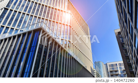 View of an modern apartment building standing next to a new modern office building with a glass facade. View of an modern apartment building standing next to a new modern office building with a glass facade. 140472260
