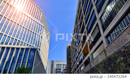 View of an modern apartment building standing next to a new modern office building with a glass facade. 140472264