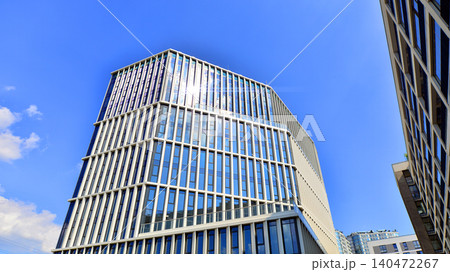 View of an modern apartment building standing next to a new modern office building with a glass facade. 140472267