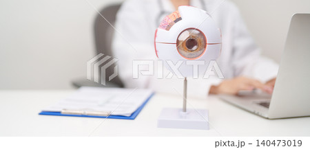 Doctor with human Eye anatomy model with magnifying glass. Eye disease, Refractive Errors, Age Related Macular Degeneration, Cataract, Diabetic Retinopathy, Glaucoma, Amblyopia, Strabismus and Health Doctor with human Eye anatomy model with magnifying glass. Eye disease, Refractive Errors, Age Related Macular Degeneration, Cataract, Diabetic Retinopathy, Glaucoma, Amblyopia, Strabismus and Health 140473019