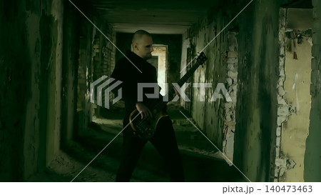 Musician playing guitar in abandoned hallway Musician playing guitar in abandoned hallway 140473463