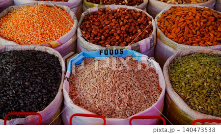 Colorful legumes, grains, nuts displayed bulk market bins overhead view 140473538