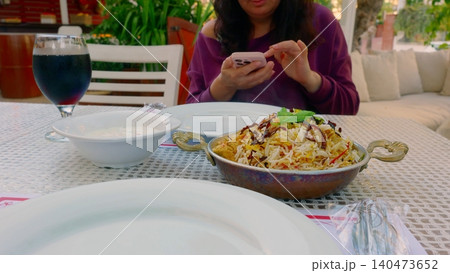 Woman photographing fried rice dish at outdoor dining table Woman photographing fried rice dish at outdoor dining table 140473652