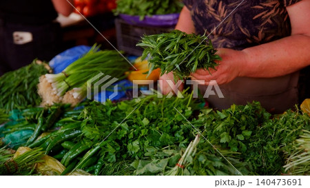 Person holding fresh herbs at market produce selection Person holding fresh herbs at market produce selection 140473691