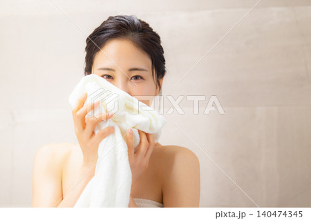 洗面所でタオルの匂いを嗅ぐ女性 洗面所でタオルの匂いを嗅ぐ女性 140474345
