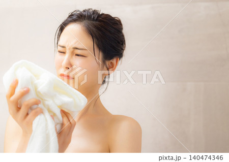洗面所でタオルの匂いを嗅ぐ女性 洗面所でタオルの匂いを嗅ぐ女性 140474346
