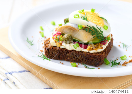 Danish open sandwich smorrebrod with herring, onion and eggs, close-up. Danish open sandwich smorrebrod with herring, onion and eggs, close-up. 140474411