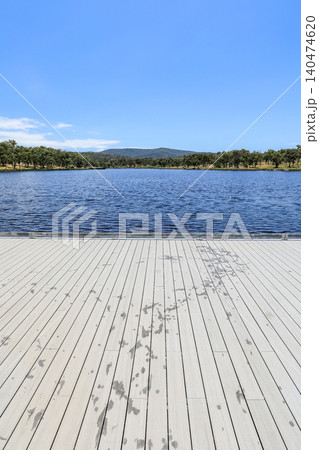 View from jetty looking across Dumaresq Dam in Armidale, New South Wales, Australia on a sunny day showing calm water and natural landscape environment in regional New England area. View from jetty looking across Dumaresq Dam in Armidale, New South Wales, Australia on a sunny day showing calm water and natural landscape environment in regional New England area. 140474620