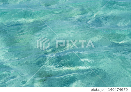 Clear turquoise water surface displays gentle waves and reflections, highlighting the vibrant colors of a tropical marine environment Clear turquoise water surface displays gentle waves and reflections, highlighting the vibrant colors of a tropical marine environment 140474679